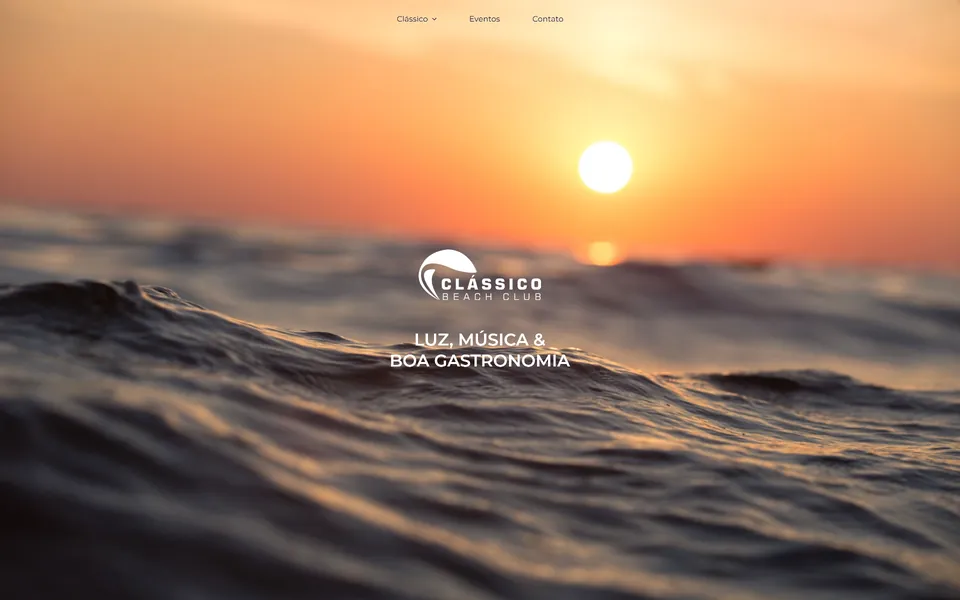 Clássico Beach Club landing page: the sun setting over the sea with the club's logo.
